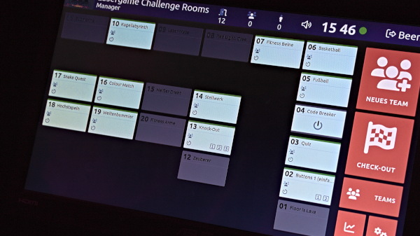 A digital display showing a schedule for Challenge Rooms with various activities and a NEW TEAM button