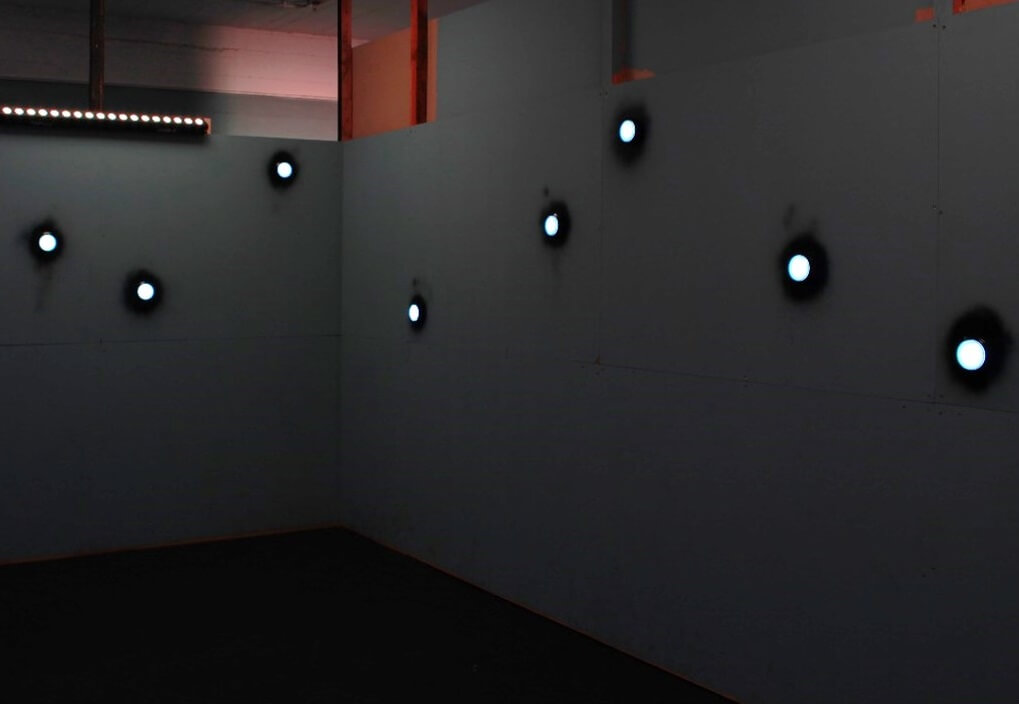 A room with eight large, round, white glowing buttons