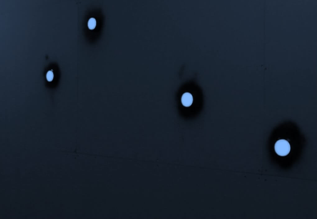 A wall with four round, blue glowing buttons