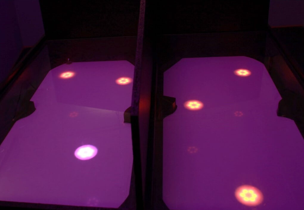 Four dark gaming areas, each with one or more glowing LED circles