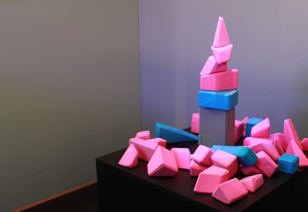 A tower made of pink, blue, and grey building blocks
