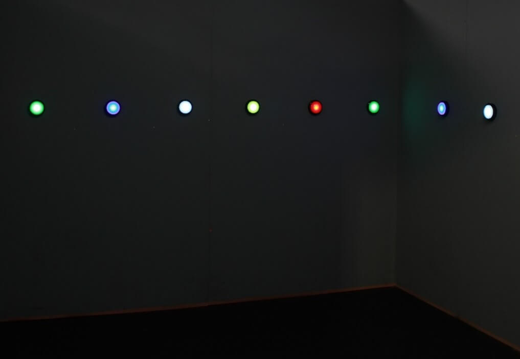 A wall with many round buttons glowing in various colours