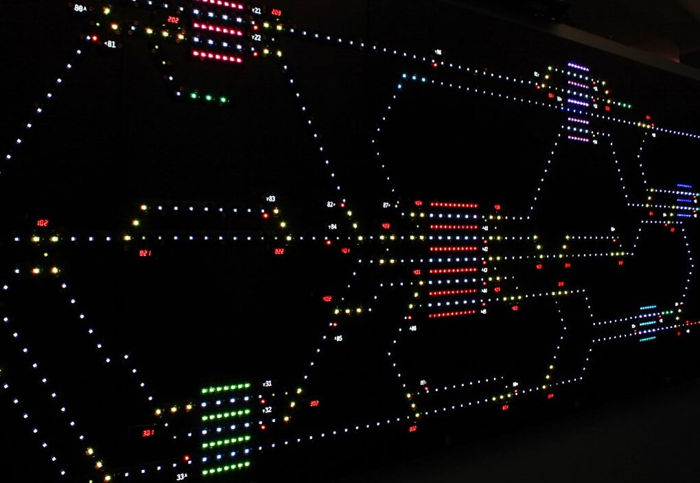 A wall with many LEDs representing a network plan with routes and stations