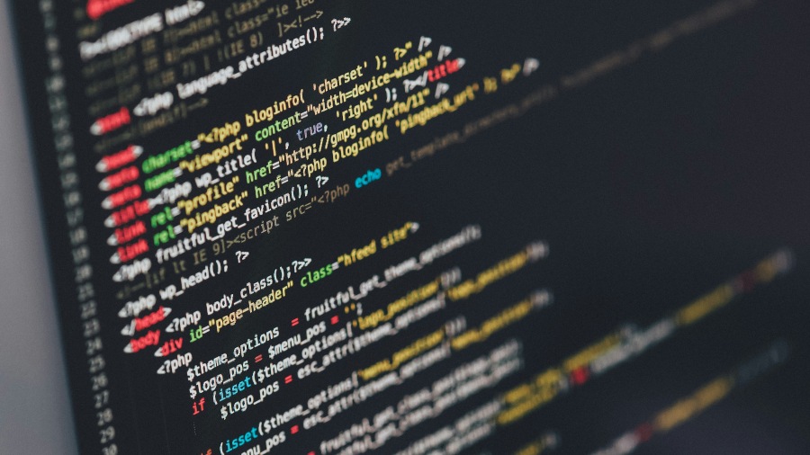 A close-up of a computer screen displaying lines of code in various colours, illustrating programming